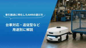 牽引搬送型AMRが工場内で台車を牽引している様子。青い台車と白いAMRが製造現場で稼働している。
